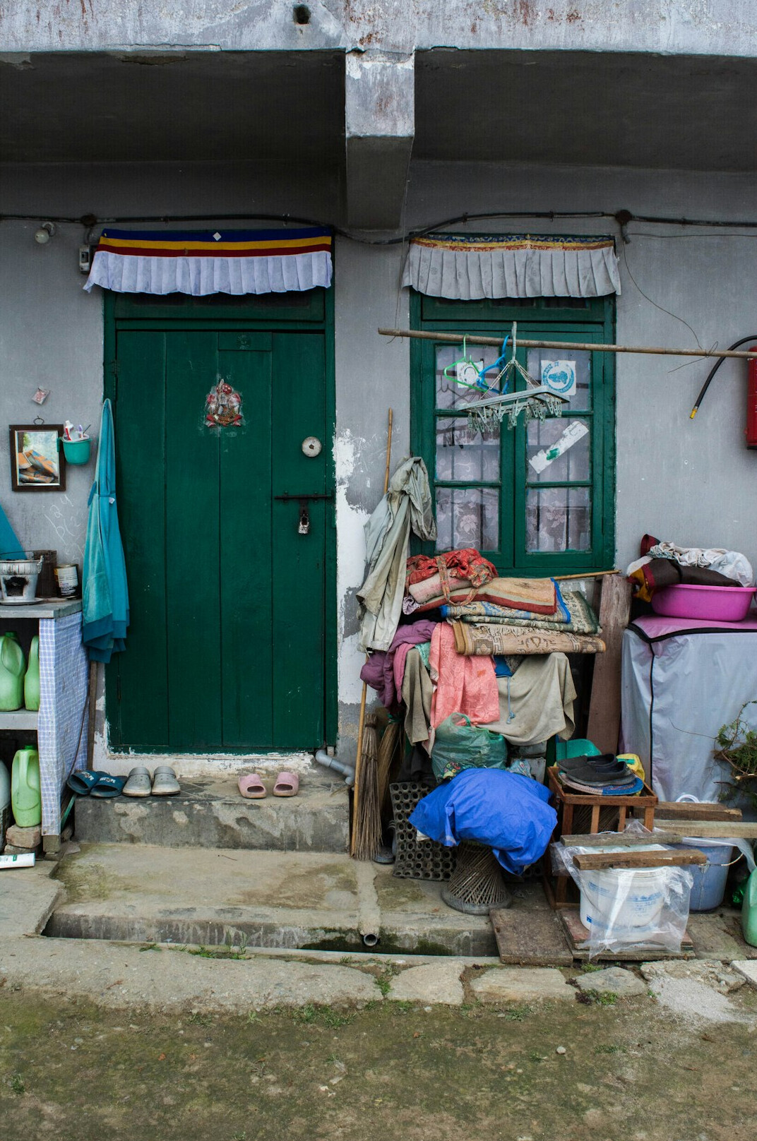 Elderly woman sitting in a doorway on a residential street