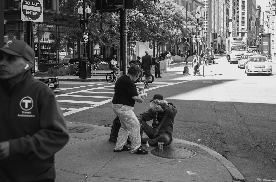 Photographer crouched down photographing a city street scene