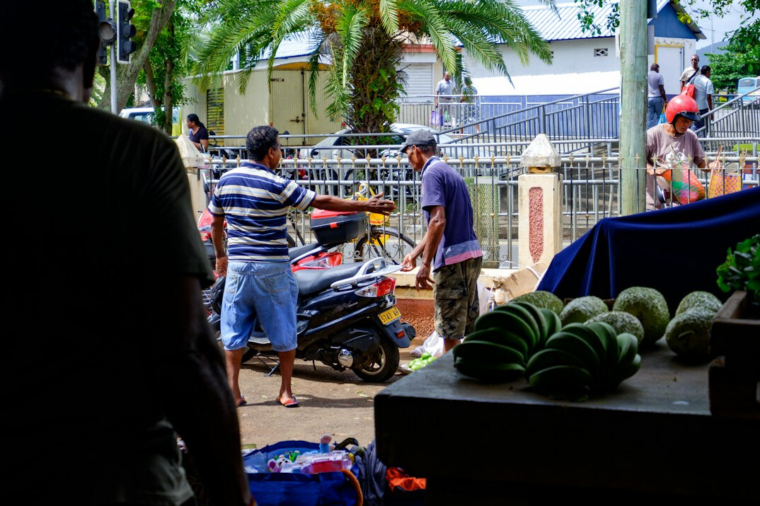 Vendor arranging fresh produce at an outdoor street market